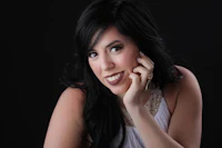 a woman with long black hair posing for a photo