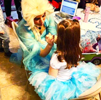 a girl in a blue dress is sitting next to a girl in a blue dress
